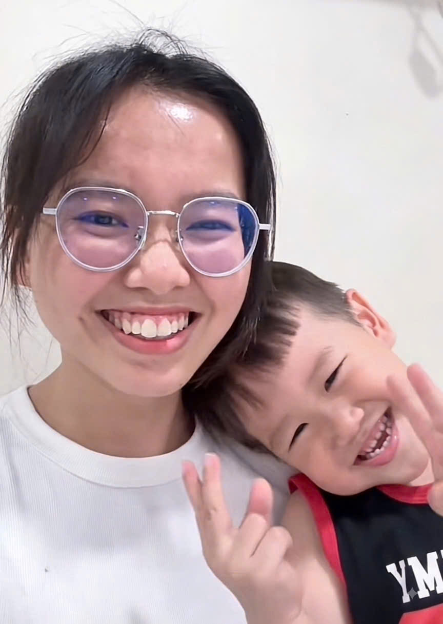 Mẹ Bon và bé Bon cười tươi, hai mẹ con cùng giơ tay tạo dáng